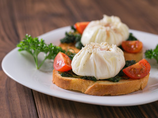 Freshly poached eggs on slices of bread on a white plate.