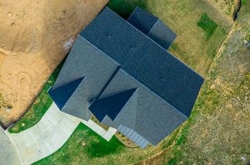 Aerial top down view of a hip and valley pitched roof on a new construction American luxury single...