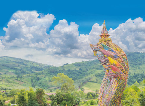 The big symbol of Phaya Naga, with blue sky cloud background, the public domain in the village and temple in Thailand.