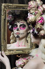 Calavera Catrina in the dark. Fashion model with sugar skull makeup. Dia de los muertos. Day of The Dead. Halloween.