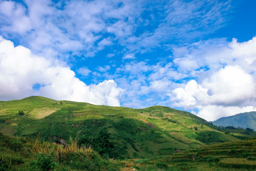 The beautiful landscape of Y Ty with mountains, clouds, blue sky, and rice fields, the most popular destination in Sapa, Vietnam. Royalty high-quality stock image of a landscape.