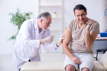 Fototapeta premium Male patient visitng doctor for shot inoculation