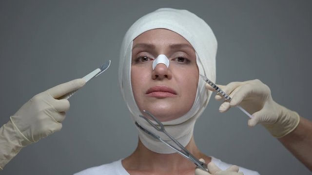 Doctors hands holding medical equipment near female face, plastic surgery