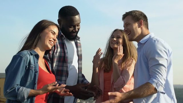 Cheerful friends enjoying roof party, having fun time together, slow-motion
