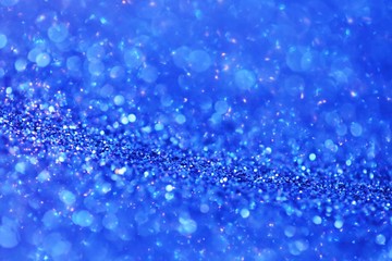 blue glitter  with bokeh background.Christmas festive winter background.Shiny texture with highlights. Blue shining  surface. sparkling shiny  paper.Christmas holiday seasonal wallpaper