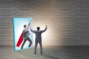 Businessman seeing himself in mirror as superhero