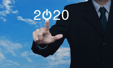 Businessman pressing 2020 start up business flat icon over blue sky with white clouds, Business happy new year cover concept