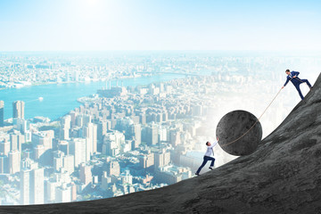 Teamwork example with business people pushing stone to top