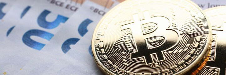 The coin of crypto currency bitcoin against background euro banknote subject gold exchange pyramid for money in connection with the growth or fall exchange rate closeup.