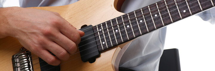 Male arms holding and playing classic shape wooden electric guitar closeup. Six stringed learning musical school education art leisure electrical vintage stage shop having fun enjoying hobby concept
