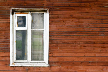 window with white frame on a old brown wooden wall