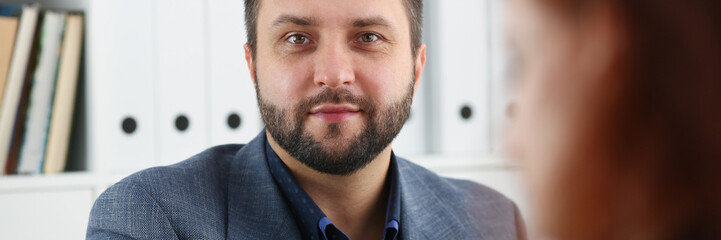 Obraz premium young beautiful red haired woman sit at table in office in cabinet of her boss first place of work concept