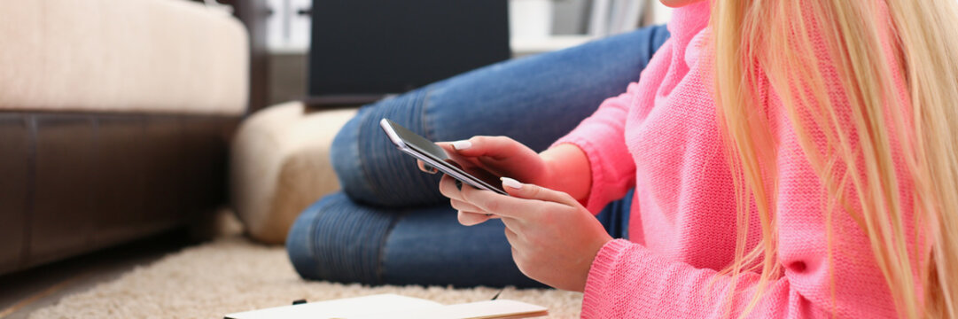 young pretty blond womansit on sofa hold smartphone in hands chat with friends