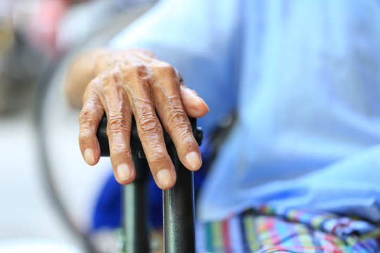 Hands of senior man sitting on bench in home - Powered by Adobe