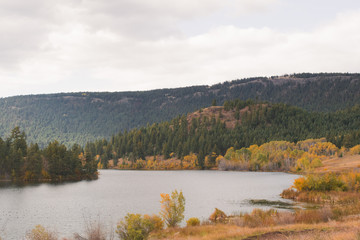 Foliage and mountains with forested trees, lake, rural and remote landscape in Lac Du Bois protected area, grasslands, Kamloops