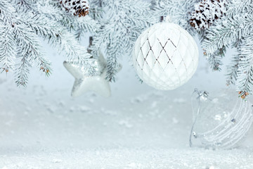 festive winter new year background with snowy fir tree branch decorated with glass balls and stars
