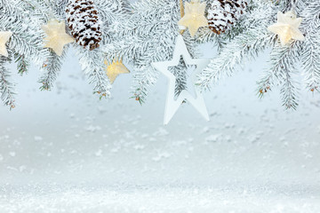 christmas background with snowy fir tree branches, cones and garland lights with star