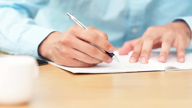 ノートに書く男性