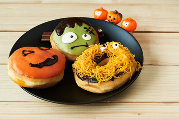 Three halloween doughnut on wooden background