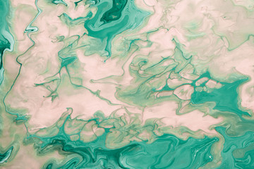Free flowing beige and green acrylic paint. Abstract marble background or texture. Random Waves and Curls