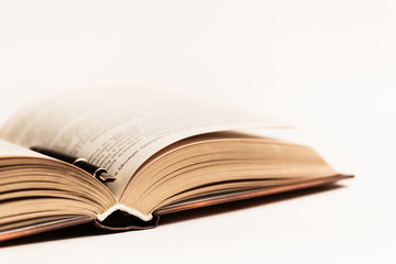 Black and gold expensive fountain pen lies on an open book. Macro photo.
