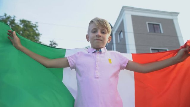 Italian football fan waving national flag, cheering team outside, championship