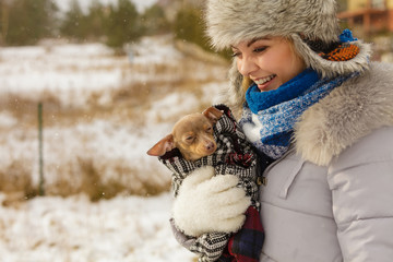 Woman hug warming her little dog in winter