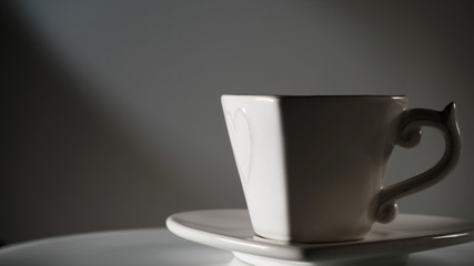 Empty heart shaped cup rotating on dark