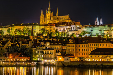 Naklejka na ściany i meble Night View of Prague castle, the largest coherent castle complex in the world, with the reflection on Vltava river.