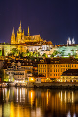 Fototapeta na wymiar Night View of Prague castle, the largest coherent castle complex in the world, with the reflection on Vltava river.