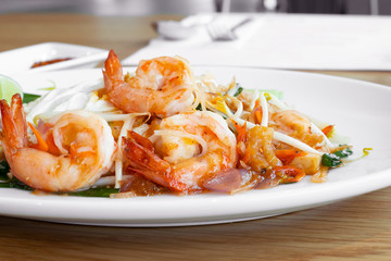 Close-up Pad Thai, Thai traditional food, or rice noodles with fresh shrimps and vegetables. Front view