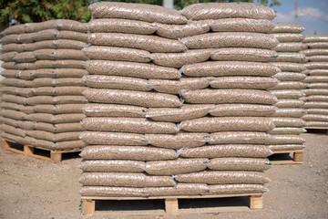 Piles of plastik bags full with wooden pellets  in rows and columns