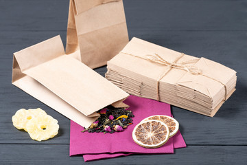 .black Ceylon tea in a food paper eco bag on a black wooden background. concept of eco packaging