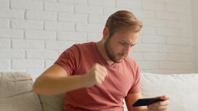 Sports Fan Reaction Concept - Disappointed reaction of a sports fan watching his favourite team/player on smart phone, 4k
