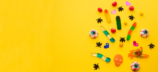 halloween candies seen close up on yellow background