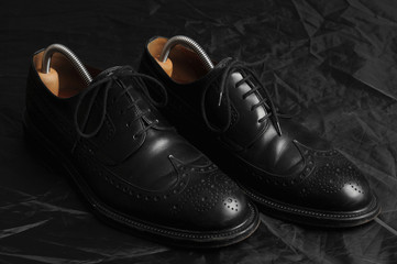 Leather black oxfords and brush. Studio photography