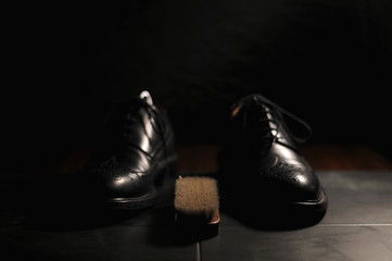 Leather black oxfords and brush. Studio photography