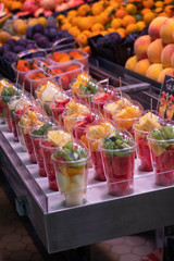 slices of various fruits in a container on the market