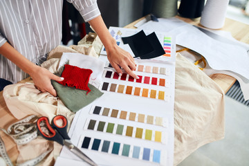 talented designer selecting colours for new garment, close up photo. side view image. job, profession, occupation