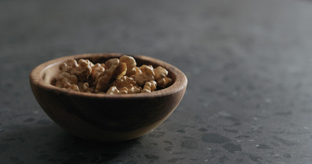 walnut kernels in wooden bowl on terrazzo countertop