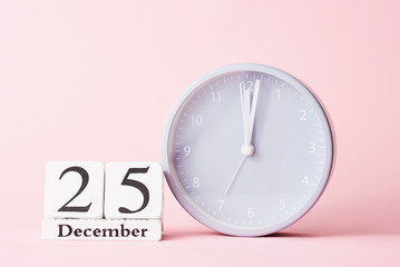Christmas background with alarm clock on pink background