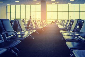 Passenger seat in Departure lounge for see Airplane, view from airport terminal, waiting for  Boarding,sun light in vintage color selective focus, transport and travel concept