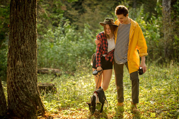 young loving couple enjoying walking with afro dog, full length photo. love, family, relationship