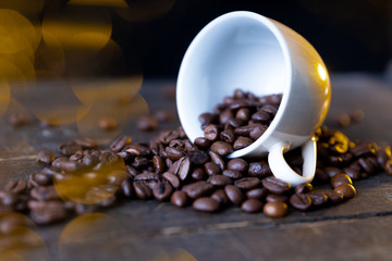 Espressotasse voller Kaffeebohnen auf einem Holztisch