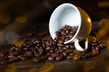 Espressotasse voller Kaffeebohnen auf einem Holztisch