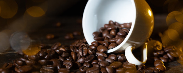 Espressotasse voller Kaffeebohnen auf einem Holztisch