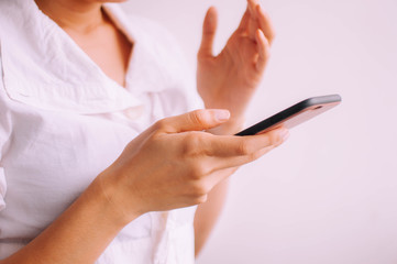 A close-up view of a young woman holding a smartphone on a white background