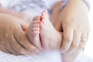 Obraz na płótnie Canvas Feet for newborns in mother's hands