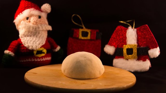 pizza dough that rises with the background of Santa Claus and his clothes ideal for Christmas dinner