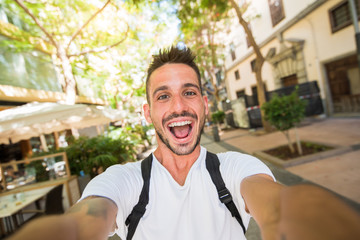 Handsome man takes a selfie walking in the city